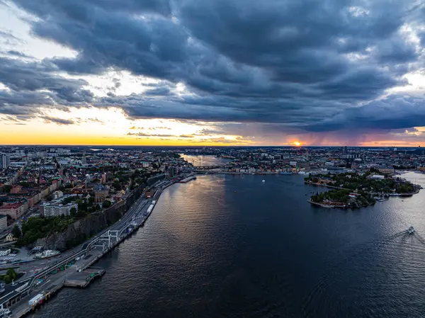 Gün batımında Stockholm 'ün büyüleyici hava manzarası dramatik bulutlar ve bu sakin İskandinav başkentindeki su yansımaları ile gökyüzüne yükseliyor..