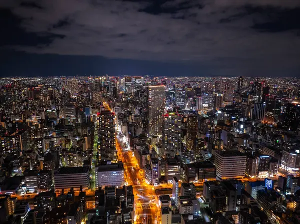 Geceleri yüksek binalar ve aydınlık caddelerle Osaka 'lar Japonya' da çarpıcı bir gece göğü altında çarpıcı bir şehir manzarası yaratıyor..