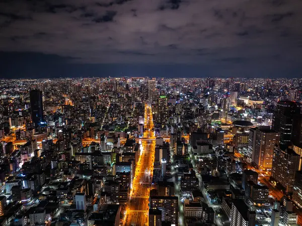 Japonya 'nın Osaka şehrinin büyüleyici gece manzarası, yüksek binalar ve yukarıdan görülen canlı caddeler, metropolün canlı kentsel enerjisini yakalıyor..