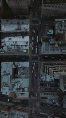 Dikey video, New York şehrinin kentsel manzarasını vurgulayan trafik ve yüksek gökdelenlerle dolu bir caddeyi gözler önüne seriyor..