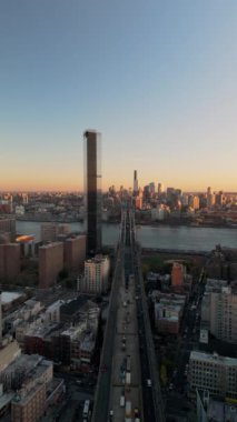 Doğu Yakası Manhattan 'daki Williamsburg Köprüsü' ne doğru bir trafik akışı var. New York silueti dikey bir videoda yüksekte duruyor.
