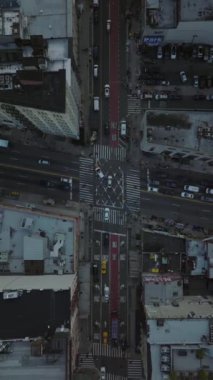 Yavaş çekimde dikey hava görüntüsü, Manhattan, New York 'ta bir kavşakta yol alan sarı taksi ve arabaları yakalıyor. Şehir trafiğini ve dinamik şehir yaşamını gösteriyor..