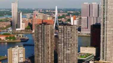 Rotterdam gökdelenleri yüksek binalar, ikonik köprüler ve aşağısı hareketli nehirlerle kaplı. Şehrin dinamik mimarisi ve su yolları.