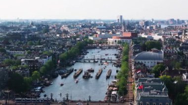 Amsterdamlar, tarihi binalarını, ikonik kanallarını ve canlı su yollarını gösteren kuşbakışı bir kuşun cazibesine sahip. Şehrin mimari güzelliğini çarpıcı bir şekilde yansıtıyor..
