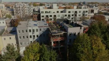 İnşaat işçileri Brooklyn, New York City 'deki bir apartmanın çatısına ek bina kuruyor. Kentsel gelişim ve yerleşim alanlarında devam eden büyüme.
