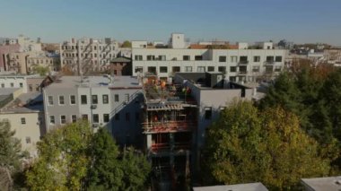 Havadan alınan görüntüler Brooklyn, New York 'ta ağaçlarla kaplı bir caddeyi yakındaki ağaçlık bir sokak boyunca sonbaharda kaldırımları ve mimariyi gösteriyor..