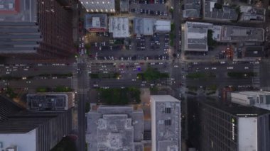 Alacakaranlıkta büyük bir Amerikan şehrinin şehir merkezinin kuş bakışı manzarası, kesişen caddeler ve binalar ile şebekelerin yerleşim yerlerini ve kentsel gece manzarasını gösteriyor..