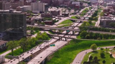 Hava manzarası, arka planda şehir binaları ve üstgeçitlerle Kansas City, Missouri 'nin hareketli otoyollarını ve yeşil alanlarını gösteriyor.