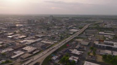 Gün doğumunda Birmingham, ABD 'deki otoyolun hava görüntüsü, şehir manzarası, binalar ve arabaların açık havada yumuşak güneş ışığıyla geçişi..