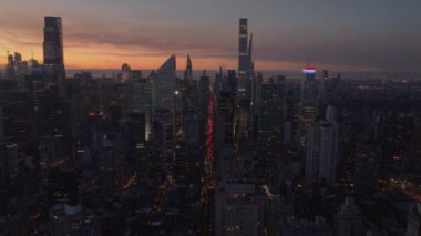 Manhattan 'ın göbeğinde güneşlenen New York şehri silueti ılık turuncu ve sarı tonlarda, ikonik mimariyi vurguluyor ve canlı şehir manzarasını canlandırıyor..