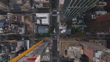 Havadan bakıldığında, canlı bir New York caddesi üzerinde dönen bir inşaat vincinin canlı şehir manzarasını ve metropolde devam eden gelişmeleri vurguluyor..