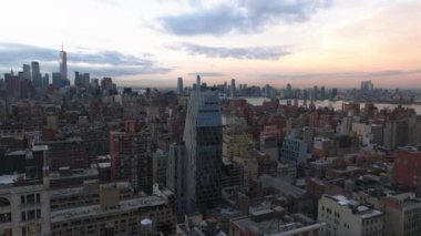 Havadan bakıldığında New York Citys ikonik ufuk çizgisini vurguluyor, Hudson Nehri üzerinde güneş batıyor, şehir manzarasını canlı renklerle boyuyor ve yüksek binaları aydınlatıyor..