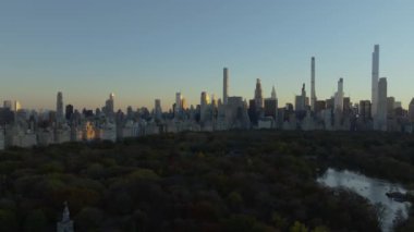 Central Park 'ın hava manzarası günbatımında Manhattan' ın şehir merkezinde modern ve klasik gökdelenleri aydınlatır..