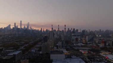 Arka planda Queens yerleşim binalarının, Ravenswood Üretim İstasyonu 'nun ve Manhattan gökdelenlerinin havadan görüntüsü var..