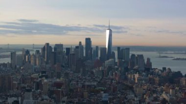Bir Dünya Ticaret Merkezi 'nin havadan görünüşü ve gün doğumunda Manhattan' ın aşağısı aydınlanıyor. Şehir doğudaki nehirde güneş doğarken yavaşça uyanıyor..