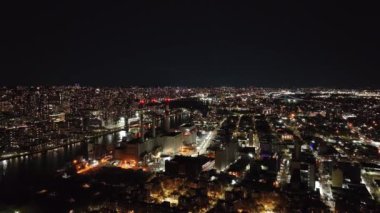 Queens, New York 'ta canlı bir mahalle olan Long Island City' de gezinen Ravenswood Üretim İstasyonu gece gökyüzüne karşı.