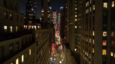 Gece yarısı Manhattan şehir merkezinde, New York caddesinde kameralar kayar, araba sürerken arabaları yakalar ve apartman pencereleri içerisinin sıcak ışıklarıyla parlar..