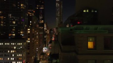 Manhattan, New York 'un merkezindeki aydınlık caddelerin ve gökdelenlerin üzerinde kameralar, metropolün ve yerleşim yerlerinin ışıklarının enerjisini gösteriyor..