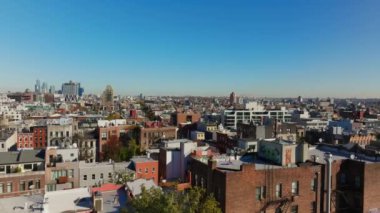 Brooklyn, New York 'taki Williamsburg' un hava manzarası, canlı kentsel manzaraların çatılarla ve hareketli sokaklarla dolu olduğu güneşli bir günü vurguluyor..