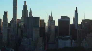 Hava görüntüsü, Manhattan şehir merkezindeki gökdelenleri aydınlatan güneşi ve 5. Cadde 'deki trafiği gösteriyor. Central Park, ön plandaki manzarayı görüntülüyor..