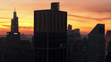 Hava görüntüsü Manhattan ufuk çizgisini gösteriyor, Metlife Binası ve gökdelenleri gün batımında vurguluyor. Alacakaranlık renkleri şehir manzarasını ve New York City mimarisini geliştirir.