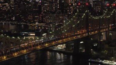 Gece vakti aydınlık Queensboro Köprüsü 'nden geçen arabalar Manhattan ve Queens' in New York ilçelerini birbirine bağlıyor..