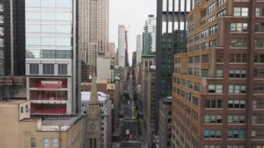 Hava görüntüleri, etkileyici gökdelenler ve dinamik kentsel manzarayla çevrili trafikte sallanan arabalar ve kamyonlarla dolu canlı bir New York caddesi yakalıyor..