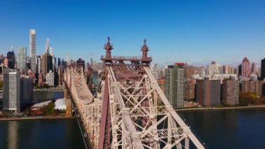 Gökdelenler Queensboro Köprüsü üzerinde süzülüyor, ikonik gökdelenleri vurguluyor ve Manhattan 'ın ortasındaki canlı şehir, New York City gökyüzü altında sonbaharda berrak mavi bir gökyüzünün altında gökyüzü var..