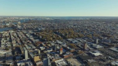 Queens, New York 'un şehir manzarası, arka planda Yukarı New York Körfezi ile sonbaharda renk değiştiren cadde, bina ve ağaçların şebeke modelini gösteriyor..
