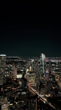 Aydınlatılmış Long Island City, Queens, New York gökdelenleri dikey manzaralı gökyüzü. Kamera canlı şehir sahneleri sergiliyor. Parıldayan ışıklarla dolu..