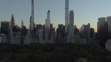 Güneş batarken Central Park 'ın güneyindeki hava manzarası ve arka planda Manhattan şehir merkezi silueti beliriyor..