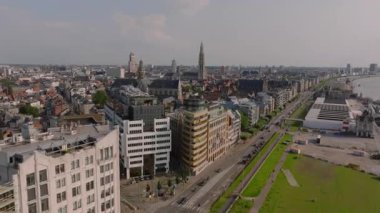 Antwerps 'in canlı şehir manzarası Loodswezen, Scheldt nehri, arabalar yollar boyunca ilerliyor ve yayalar canlı bir şehir atmosferinin tadını çıkarıyorlar..