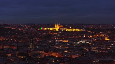 Prag 'ın büyüleyici alacakaranlık manzarası aydınlanmış kaleyi gözler önüne seriyor, şehrin olağanüstü mimarisini ve karanlık gökyüzüne karşı canlı bir ufuk çizgisi seriyor..
