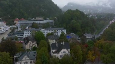 Avusturya 'nın Salzburg kentini kaplayan sisli ağaçlarla çevrili binaların ve sokakların hava manzarası.
