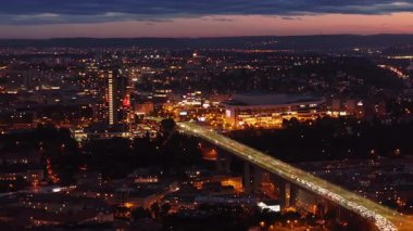 Prag Nusle Köprüsü 'nün hava manzarası. Alacakaranlıkta şehir manzarasını aydınlatan arabalar. Şehir manzarası, şehirlerin büyüleyici parıltısını gözler önüne seriyor..