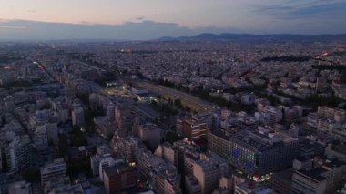Gün batımında Selanik 'in sabit hava manzarası. Güneş batarken ve gökyüzü yavaşça kararırken benzersiz bir üçayak açısıyla yakalanır. Binalar ve sokaklar solan ışıkla aydınlanır...