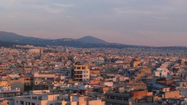 Yunanistan 'ın Selanik kentinin arka planda Chortiatis Dağı ile hava manzarası görülüyor. Yerleşim ve ticaret binaları batan güneş tarafından aydınlatılır..