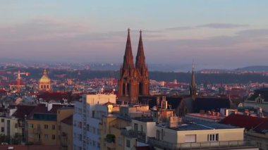 Güneş ışığı Prag siluetini silip Bazilika Sv 'den uzun gölgeler bırakır. Ludmily ve diğer simgeler gün batımında.