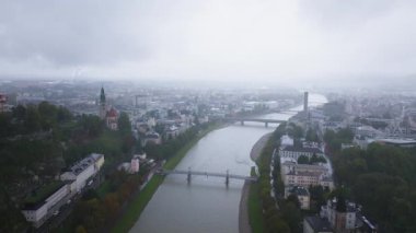 Kasvetli bir günde şehrin üzerinde sürüklenen bulutlar, Salzkammergut nehrinin Salzburg, Avusturya 'yı kaplayarak kentsel manzarayı ve tarihi mimariyi vurguluyor..