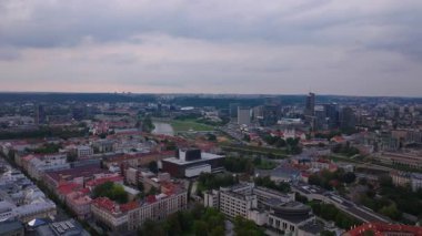 Vilnius, Litvanya 'nın hava manzarası, şehir merkezini gözler önüne seriyor, güneşli bir yaz gününde, bulutlara karşı Neris Nehri' ni ve modern ufuk çizgisini vurguluyor..