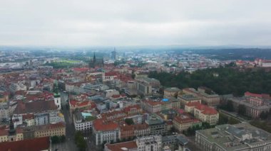Brno şehrinde hava manzarası yayılıyor. Kırmızı çatılar ve yeşil alanlar bulutlu bir günde Aziz Thomas Kilisesi 'nin etrafını sarar..