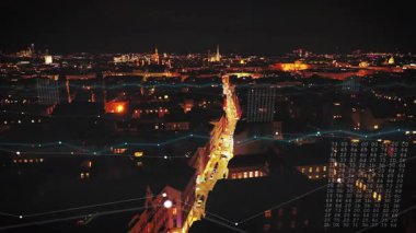 İleriye doğru, caddenin üzerinde geceye doğru parıldayarak uçar. Metropolis 'te bir akşam yemeği. Şehirdeki yayalar ve araçlar. Viyana, Avusturya. Arttırılmış gerçeklik görsel efektleri.