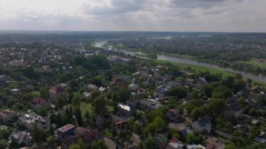 Havadan bakıldığında Neris Nehri 'nin Kaunas, Litvanya' da süzüldüğünü, bulutların parlak bir gökyüzünde tembelce sürüklendiğini, şehirlerin canlı manzarasını ve kentsel mimarisini vurguladığını görüyoruz..
