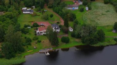 Finlandiya, Aland 'da yemyeşil ormanlarla çevrili evlerin havadan görünüşü. Kamera dönüyor ve güzel İskandinav manzarasını gözler önüne seriyor..