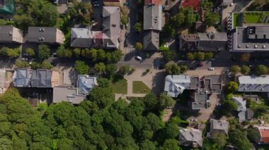 Kuş bakışı görüntüsü Kaunas, Litvanya 'nın çatılarını gösteriyor. Kamera, büyüleyici evler ve yemyeşil alanlarla dolu canlı bir mesken üzerinde sorunsuzca süzülüyor..