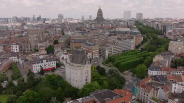 Uzakta Halle Gate ve Adalet Sarayı 'nı vurgulayan hava manzarası Brüksel şehir manzarasını gözler önüne seriyor. Güneşli bir gökyüzünün altında canlı şehir manzarası.