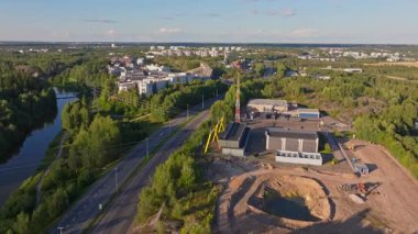 Elektrik santrali ve şantiyesi olan Helsinki banliyösünün havadan görüntüsü. Çerçevenin ortasından geçen bir otoyol boyunca arabalar sürüyor..