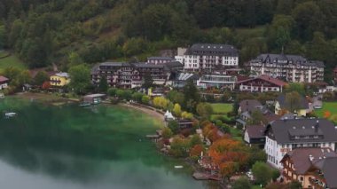 Avusturya 'daki güzel Fuschlsee' ye benzersiz bir açıdan yüksek açı, Fuschl am 'daki renkli sonbahar ağaçlarıyla çevrili lüks bir otel ve tatil köyünü gösteriyor..