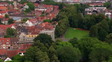 Munster 'ın hava manzarası, Almanya' nın gezinti güvertesini ve Fernsehturm Munster 'ı gözler önüne sermesi - TV kulesi. Kırmızı çatılar, yeşil ağaçlar ve manzarayı kaplayan bir şehir parkı..