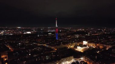 Zizkov televizyon kulesi Prag siluetinin üzerinde belirgin bir şekilde yükseliyor ve gece şehrin ışıkları parıldıyor, cezbedici bir şehir manzarası yaratıyor..